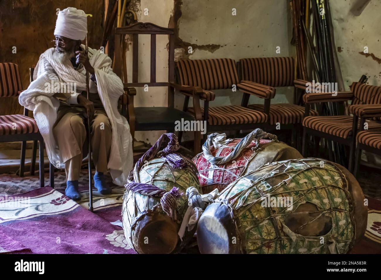 Prêtre orthodoxe éthiopien et tambours de prière dans l'église taillée dans le roc d'Abreha we Atsbeha ; région du Tigré, Ethiopie Banque D'Images