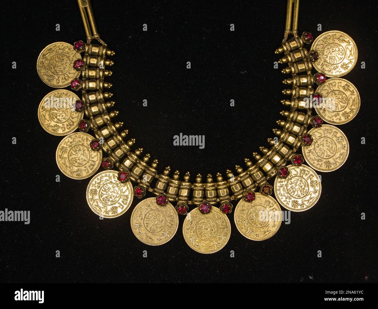 un collier d'or vintage avec un design orné et des sculptures détaillées qui a été utilisé par les royalties sur un fond noir Banque D'Images