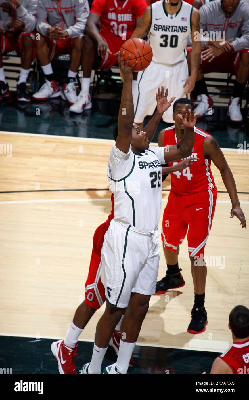 Michigan State's Derrick Nix (25) shoots against Ohio State's William Buford (44) and Shannon Scott, obscured, during an NCAA college basketball game, Sunday, March 4, 2012, in East Lansing, Mich. (AP Photo/Al Goldis) Banque D'Images