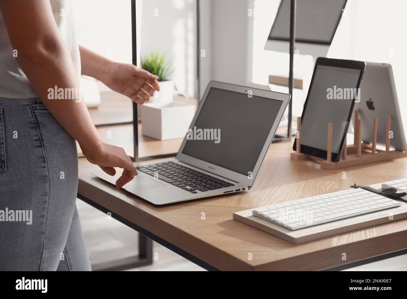 MYKOLAIV, UKRAINE - 17 AOÛT 2020 : femme choisissant MacBook dans l'Apple Store, gros plan Banque D'Images