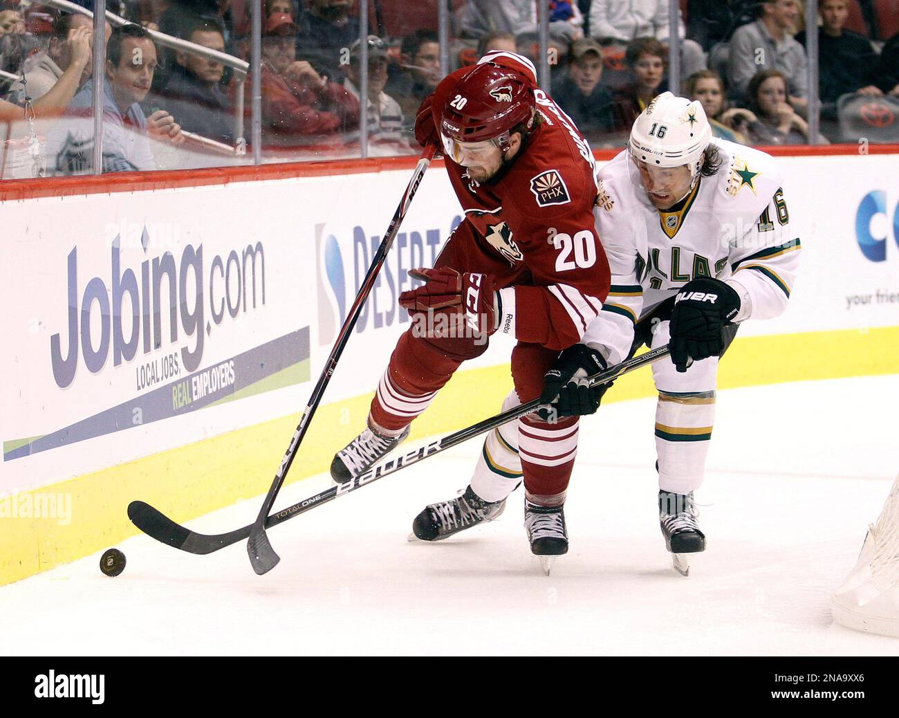 Phoenix Coyotes defenseman Chris Summers, left, and Dallas Stars right winger Adam Burish, right, battle for a loose puck in the first period of an NHL hockey game on Saturday, Feb. 18, 2012, in Glendale, Ariz. (AP Photo/Paul Connors) Banque D'Images