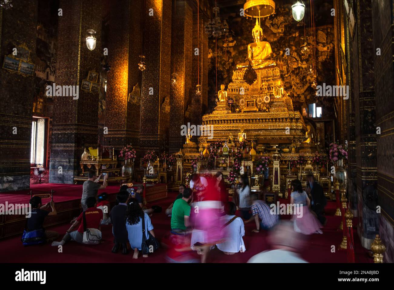 Les touristes et les dévots avant la statue de Bouddha au temple de Wat Pho à Bangkok. Banque D'Images