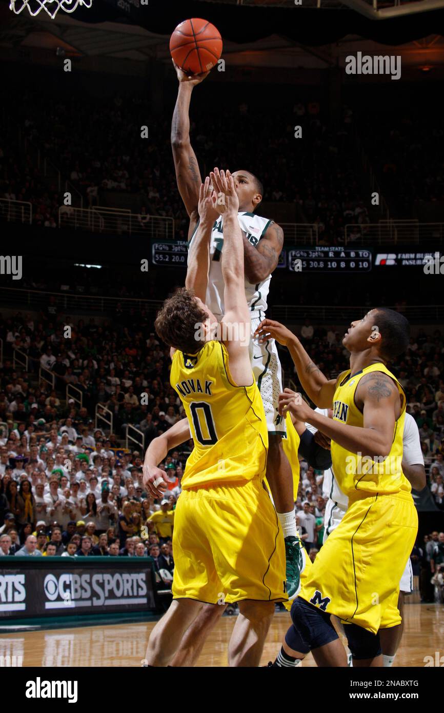 Michigan State's Keith Appling shoots against Michigan's Zack Novak (0) and Trey Burke, right, during an NCAA college basketball game, Sunday, Feb. 5, 2012, in East Lansing, Mich. Michigan State won 64-54. (AP Photo/Al Goldis) Banque D'Images