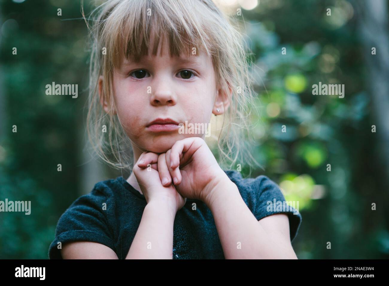 Une fille explore la forêt et a un visage sale et des cheveux sauvages Banque D'Images