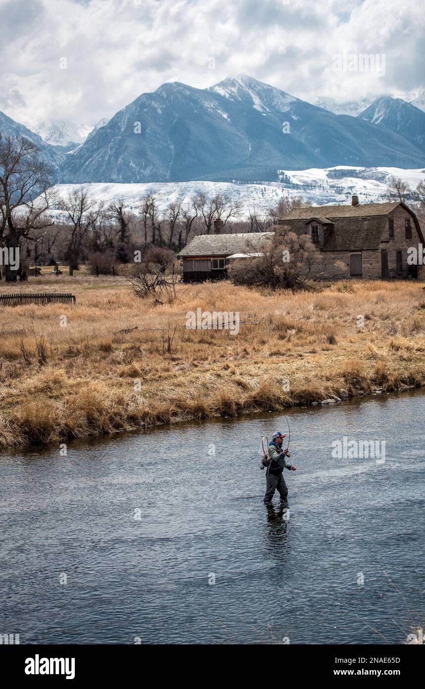 Pêche à la mouche dans la rivière avec des sommets enneigés en arrière-plan Banque D'Images