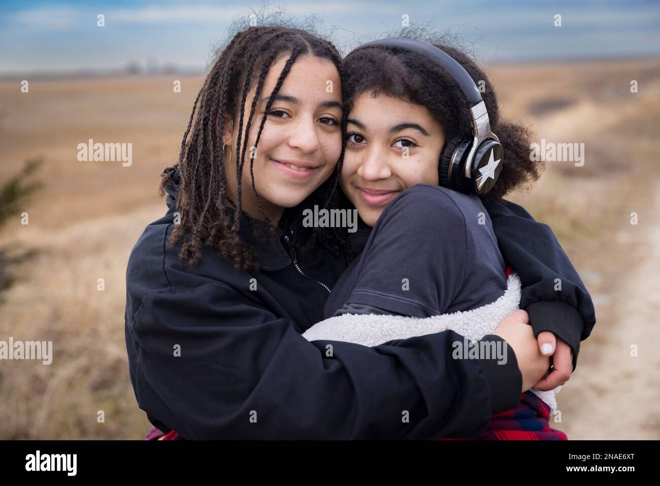 portrait de sœurs biraciales embrassant et souriant Banque D'Images