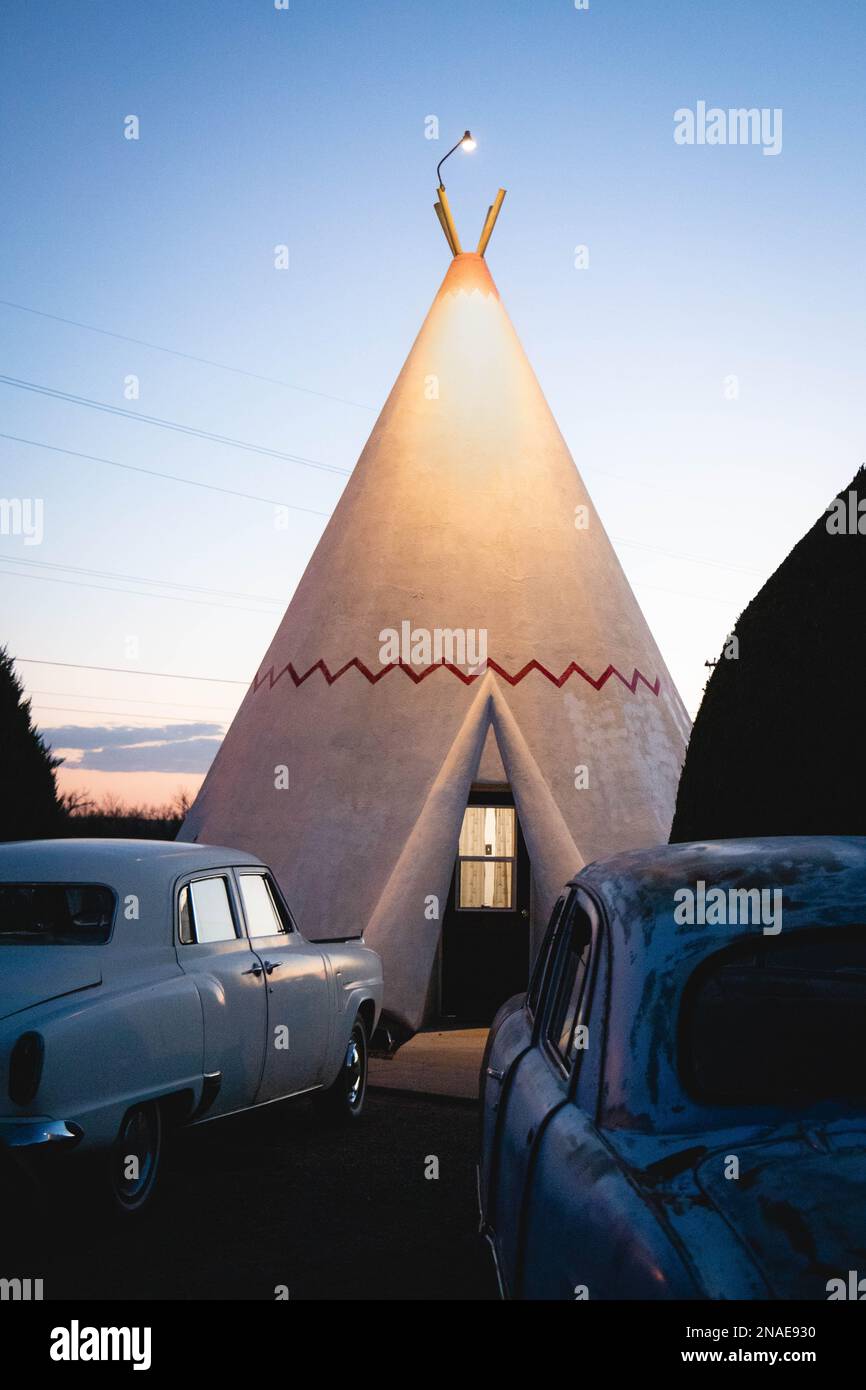 Voitures classiques rouillées garées devant le tipi au Wigwam Motel Banque D'Images