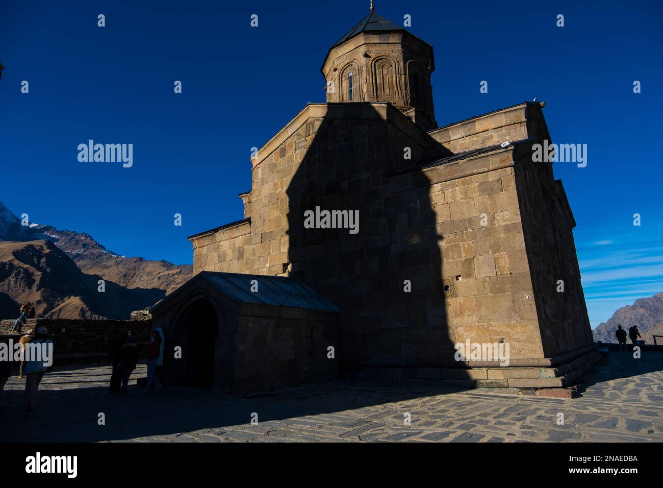 Kazbegi, Géorgie : 10-11-2022 : gros plan de l'ancienne église de la Trinité de Gergeti et des magnifiques montagnes du Caucase Banque D'Images