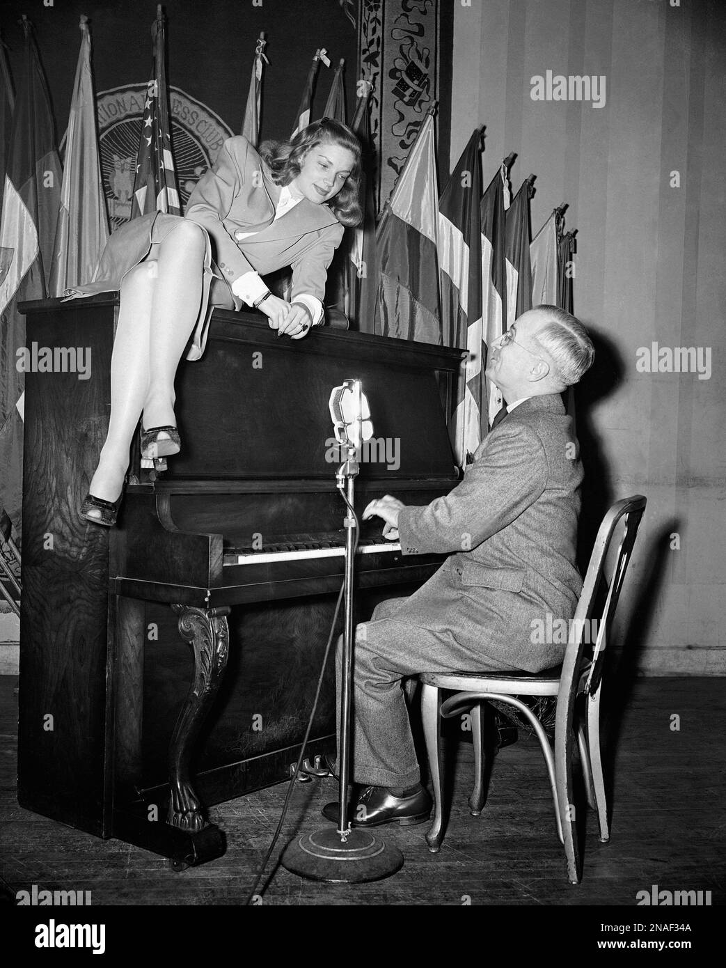 FILE - In this Feb. 10, 1945 file photo, Vice President Harry S. Truman plays the piano as new movie star Lauren Bacall lies on top of it during her appearance at the National Press Club canteen in Washington. Through the years, commanders-in-chief have turned musicians-in-chief, with varying results. (AP Photo) Banque D'Images
