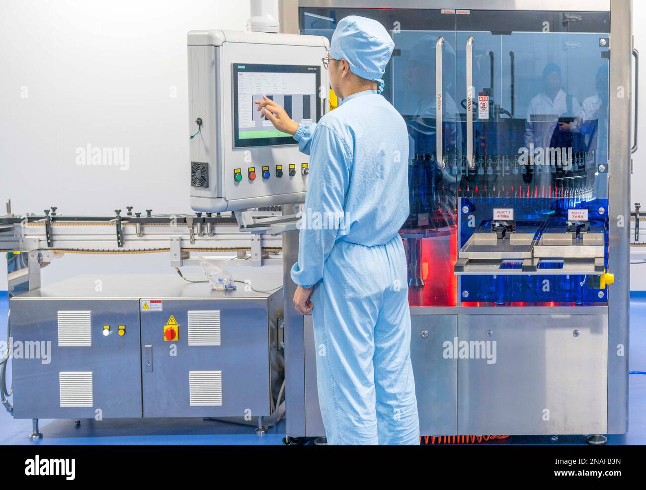 TAIZHOU, CHINE - 23 DÉCEMBRE 2021 - (FILE) des techniciens effectuent une inspection de lampe sur les produits de vaccin Covid-19 Recover à l'atelier Reco Biological in Banque D'Images