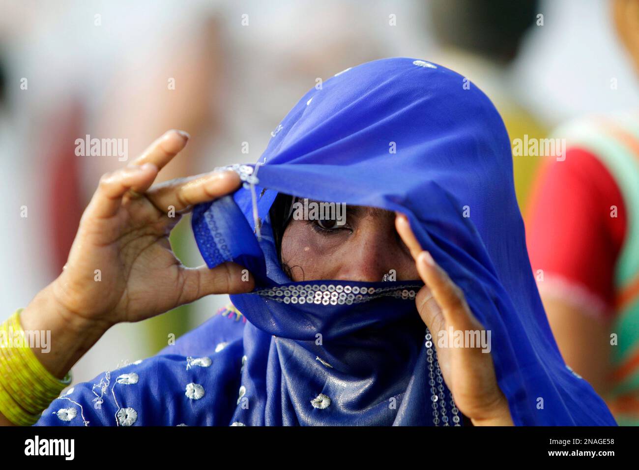 An Indian woman soaked in water looks on as she arrives at Gangasagar, on Sagar Island, the confluence of River Ganges and Bay of Bengal about 140 kilometers (87 miles) south of Kolkata, India, Friday, Jan. 13, 2012. Hindu pilgrims will take an annual holy dip on the occasion of Makar Sankranti on Jan. 14. (AP Photo/Bikas Das) Banque D'Images