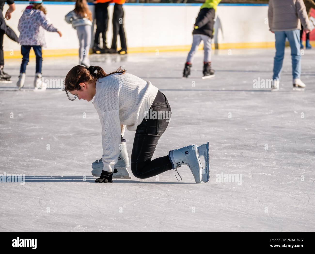 Bucarest Roumanie - 12.25.2022: Fille sur patins à glace tombant sur la patinoire du parc Cismigiu, à Bucarest Banque D'Images