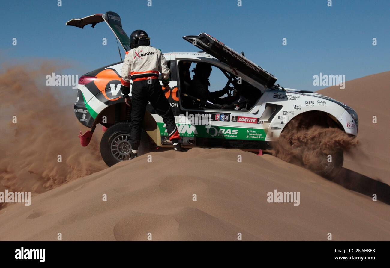Mitsubishi's driver Erik Van Loon, sitting in the driver's seat, and co-driver Harmen Scholtalbers, both from Netherlands, try to move their car after it got stuck in the sand during the seventh stage of the 2012 Argentina-Chile-Peru Dakar Rally through Copiapo, Chile, Saturday Jan. 7, 2012. (AP Photo/Martin Mejia) Banque D'Images