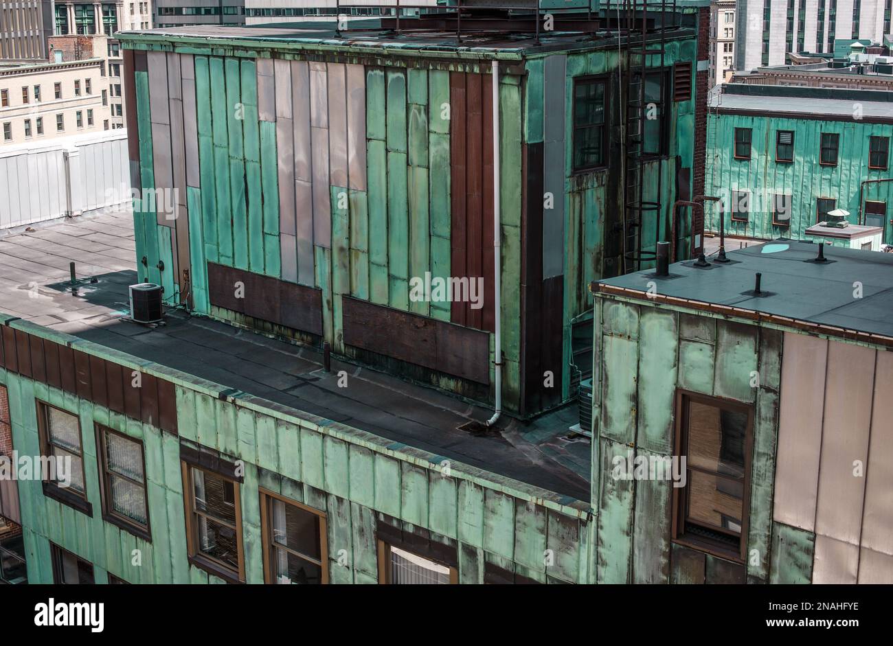 Vue sur le toit du bâtiment industriel en cuivre et en métal terni vert et argenté dans un paysage urbain Banque D'Images