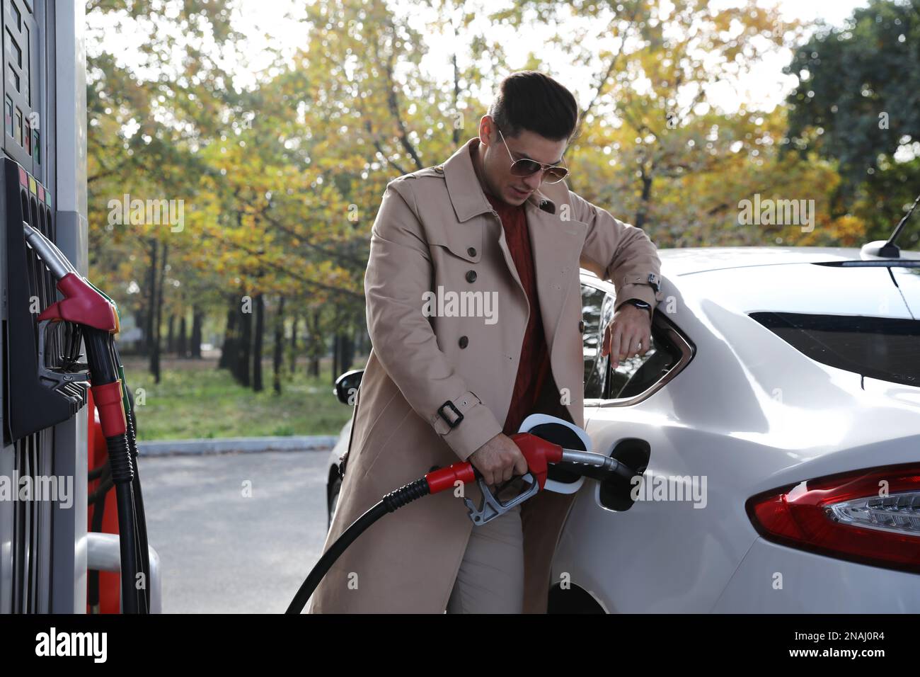 Homme ravitailleur en voiture à la station-service libre-service Banque D'Images