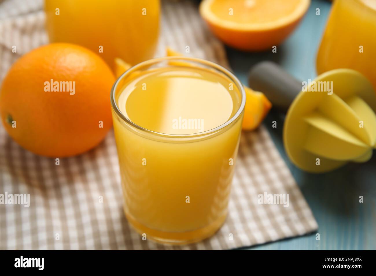 Jus, oranges et alésoir fraîchement préparés sur table en bois bleu, en gros plan Banque D'Images