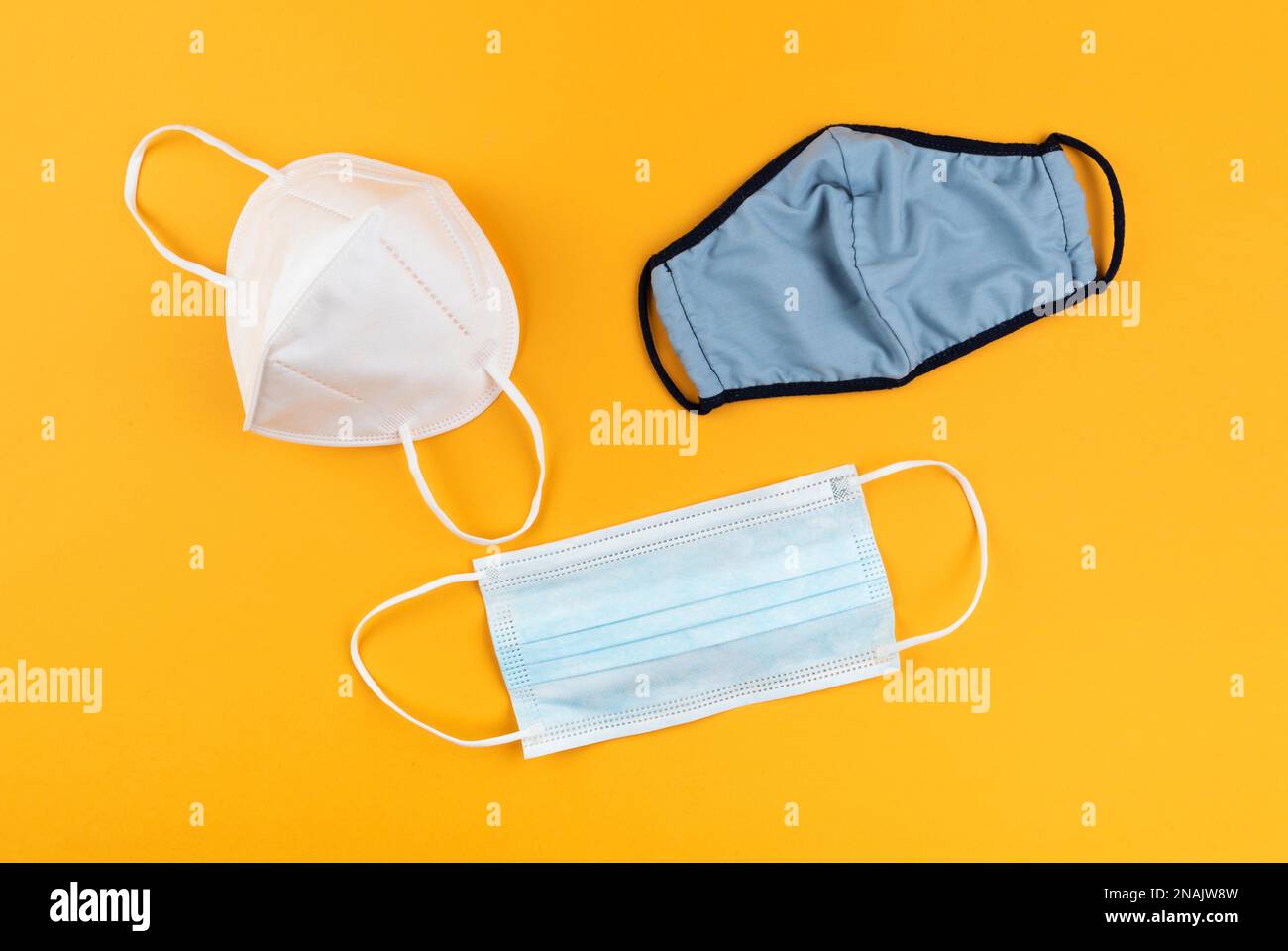 différents types de masques protecteurs ou de revêtements de visage sur fond orange vif, concept de protection du coronavirus covid-19 Banque D'Images