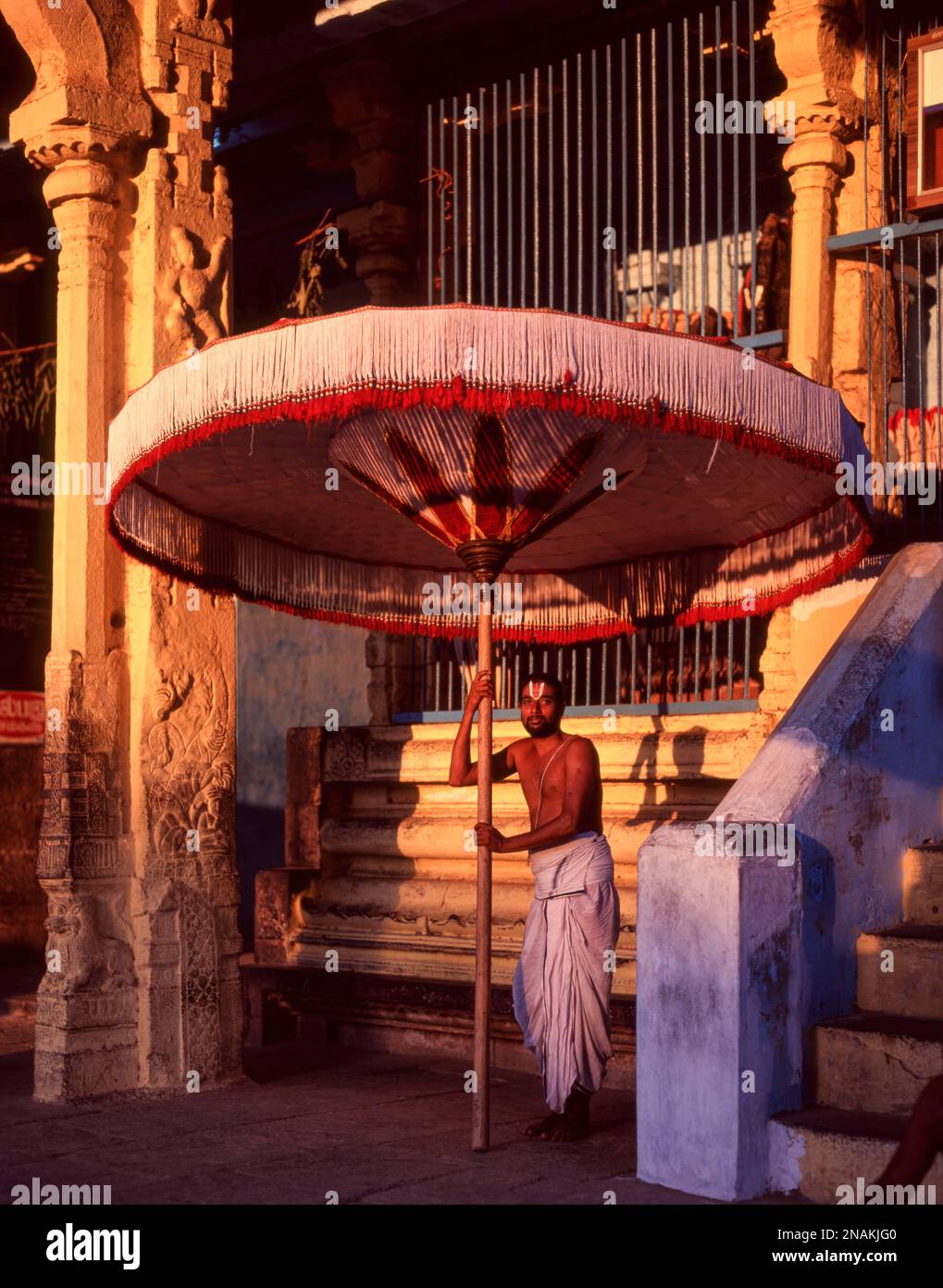 Temple Priest tenant un grand parapluie dans le temple de Varadharaja Perumal à Kancheepuram, Tamil Nadu, Inde, Asie Banque D'Images