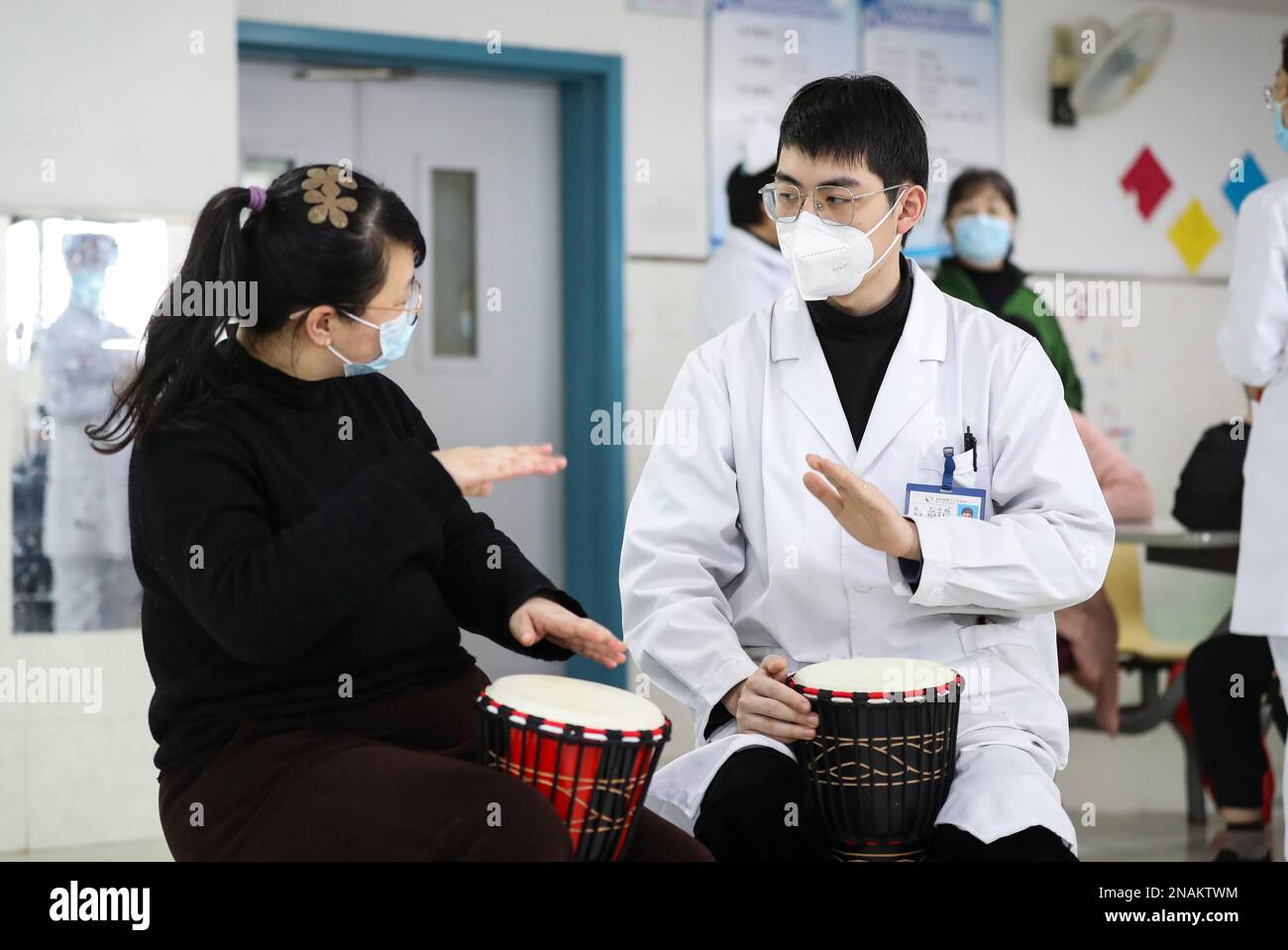 HUAI'AN, CHINE - 13 FÉVRIER 2023 - Un physiothérapeute de musique enseigne à un malade mental de jouer un tambour africain à Huai 'an, province de Jiangsu, Chi Banque D'Images