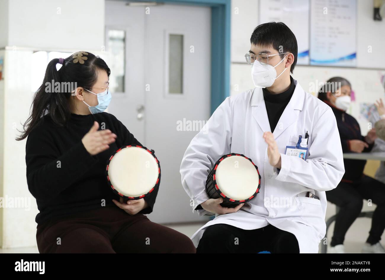 HUAI'AN, CHINE - 13 FÉVRIER 2023 - Un physiothérapeute de musique enseigne à un malade mental de jouer un tambour africain à Huai 'an, province de Jiangsu, Chi Banque D'Images