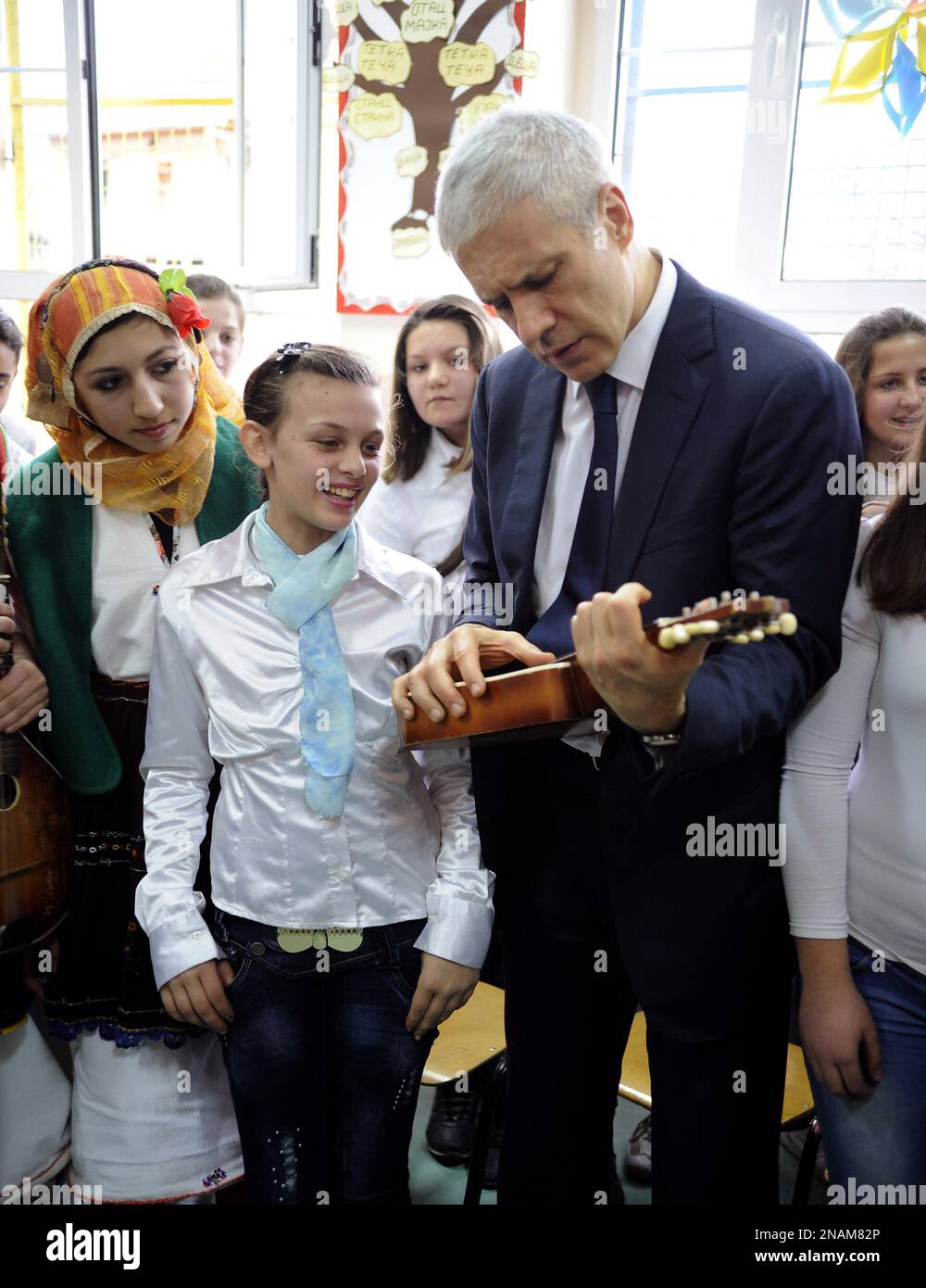 Serbia's President Boris Tadic, center, tries to play a mandolin during a visit to a school in the predominantly Serb village of Kuceviste, just north of Macedonia's capital Skopje, Saturday, Dec. 17, 2011. (AP Photo/Boris Grdanoski) Banque D'Images