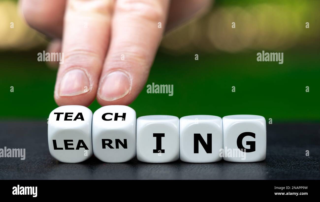De l'apprentissage à l'enseignement. La main tourne les dés et change le mot apprentissage à l'enseignement. Banque D'Images