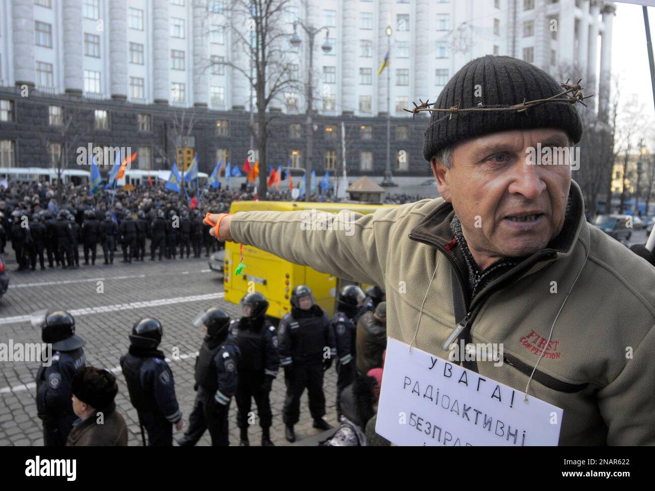 A veteran of the clean-up operation following the 1986 Chernobyl nuclear disaster wearing a placard that reads, "Warning! radioactive", attends a rally in front of the government building, Kiev, Ukraine, Tuesday, Nov. 29, 2011. The veterans were demanding the right to keep the social benefits given to them after the clean-up. (AP Photo/Sergei Chuzavkov) Banque D'Images