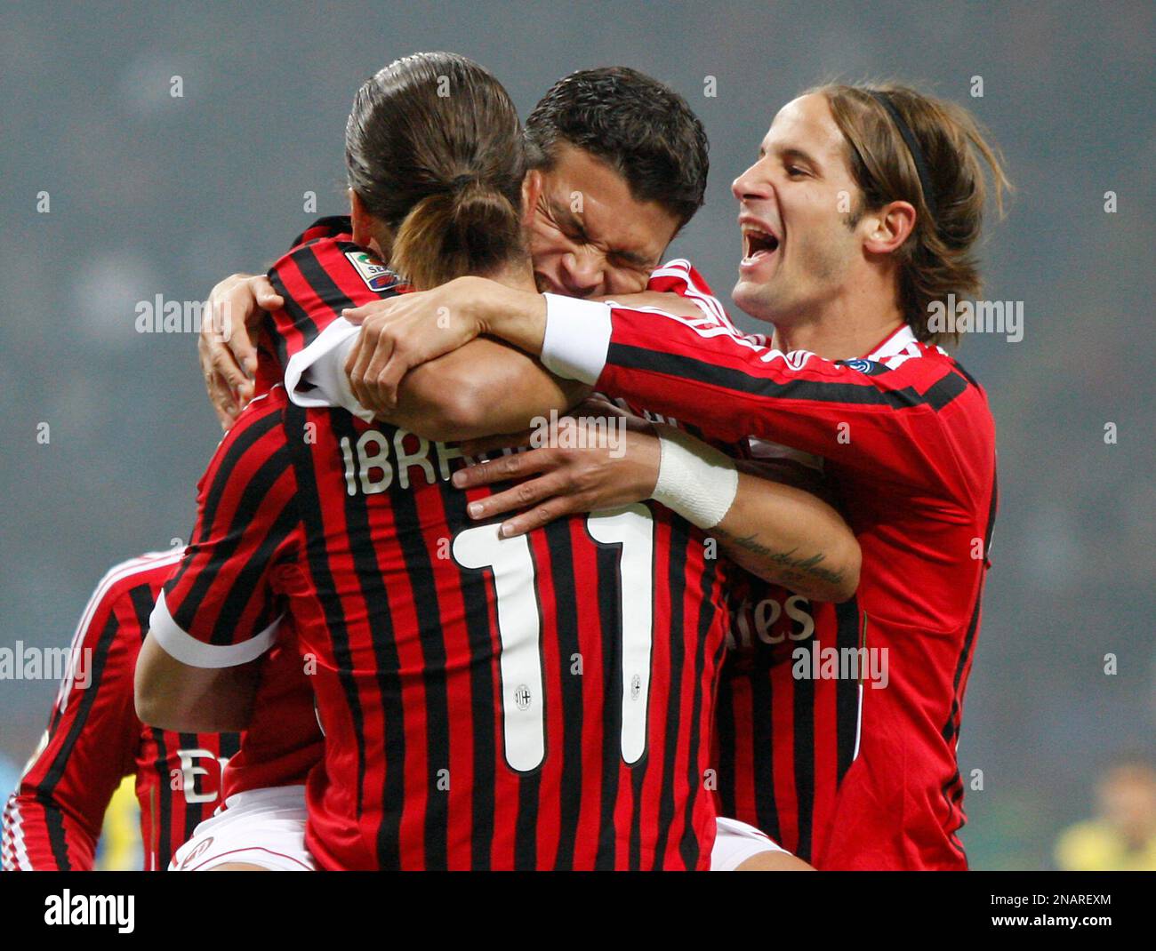 AC Milan Brazilian defender Thiago Silva, center, is embraced by teammates Zlatan Ibrahimovic (#11) of Sweden, and Luca Antonini, right, after scoring against Chievo Verona during a Serie A soccer match at the San Siro stadium in Milan, Italy, Sunday, Nov. 27, 2011. (AP Photo/Antonio Calanni) Banque D'Images