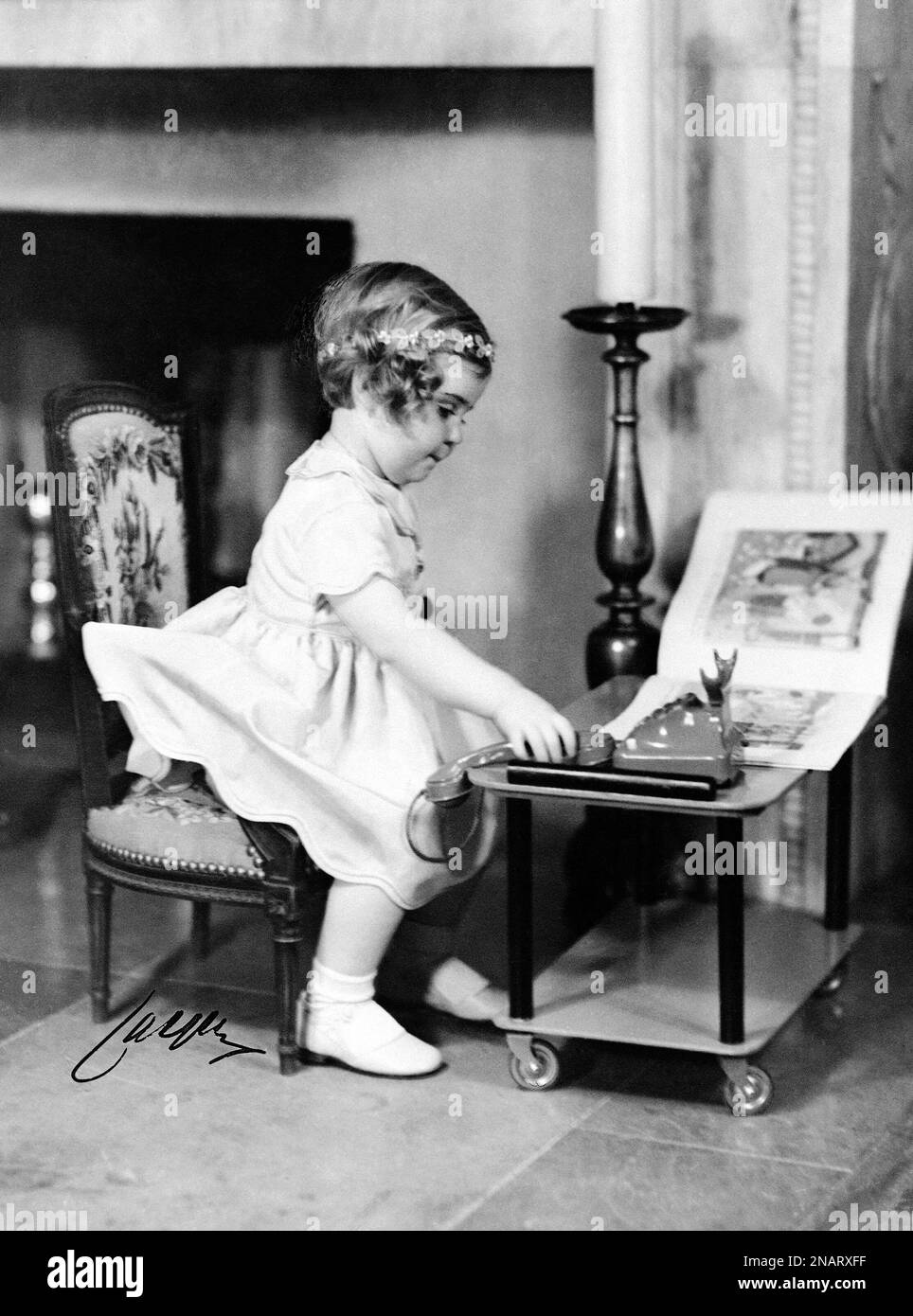 3-year-old Princess Margareta, the daughter of Prince Gustaf Adolf and Princess Sibylla of Sweden, playing with her toy phone, in Sweden, on May 6, 1937. (AP Photo) Banque D'Images