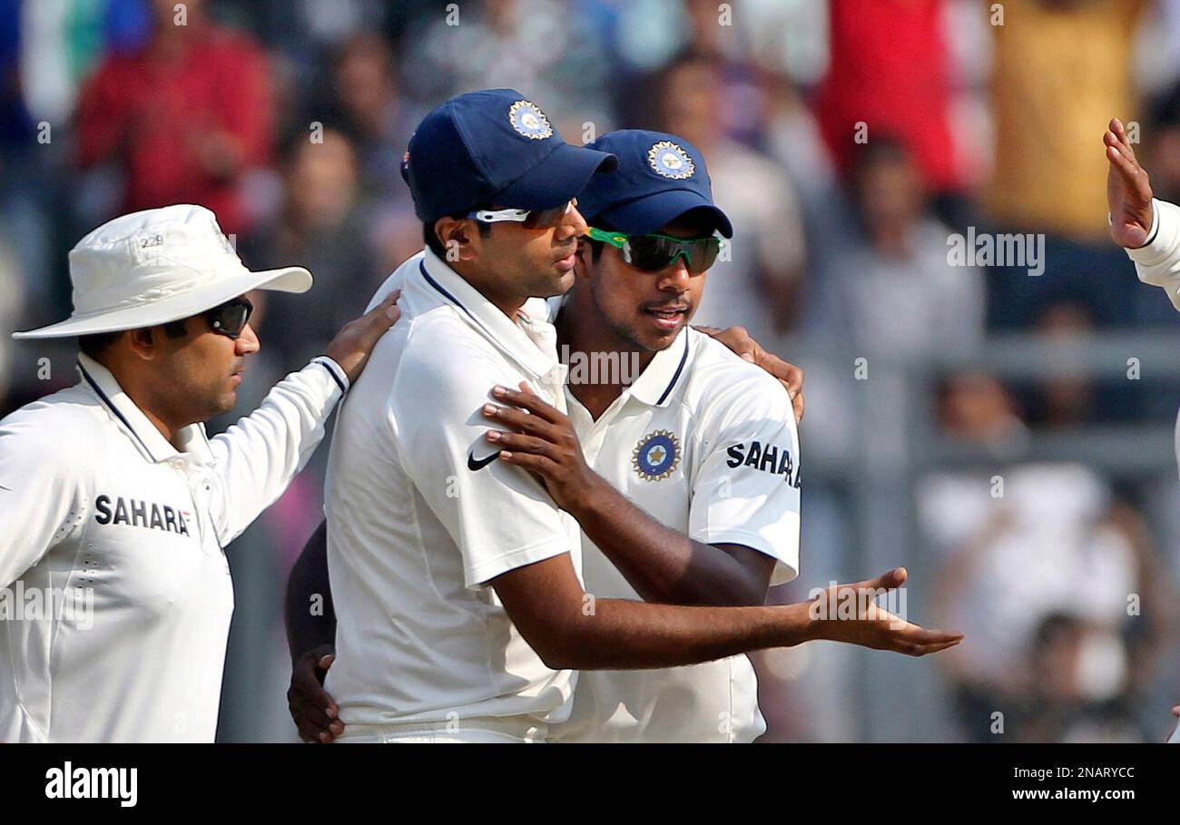 Indian cricket player Ravichandran Ashwin, center, celebrates with Virender Sehwag, left, and Varun Aaron his fifth wicket during the third day of the third test cricket match against West Indies in Mumbai, India, Thursday, Nov. 24, 2011. Ashwin took his second five-wicket haul in only his third test with figures of 5-156. (AP Photo/Rajanish Kakade) Banque D'Images