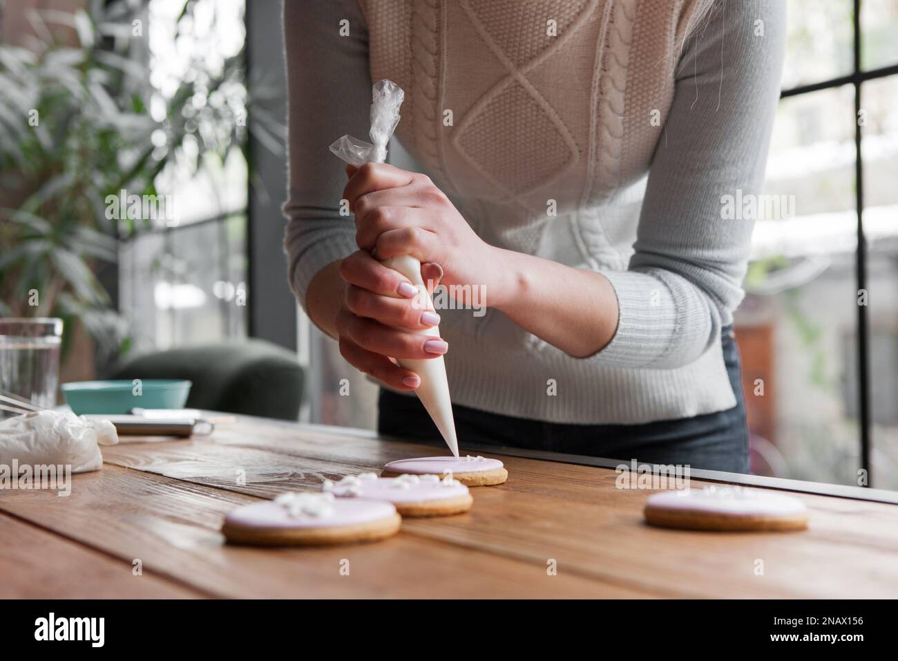 Femme chef décorant pain d'épice avec sac de pâtisserie Banque D'Images