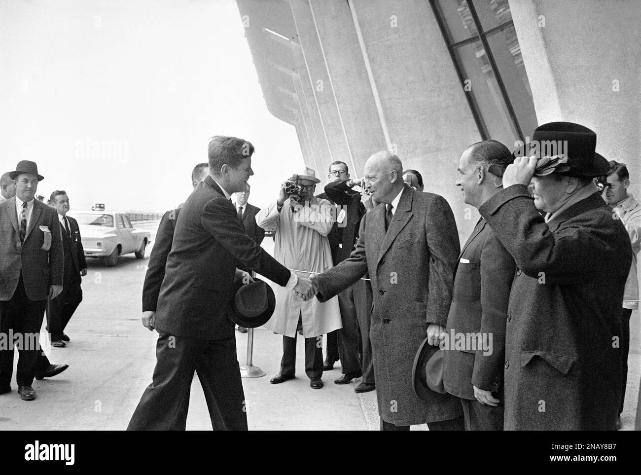 President John F. Kennedy shakes hands with former President Dwight D. Eisenhower as they meet at their arrival at the entrance to Dulles Airport, Virginia, Nov. 17, 1962, to take part in the dedication of the new jet landing facility. (AP Photo/John Rous) Banque D'Images
