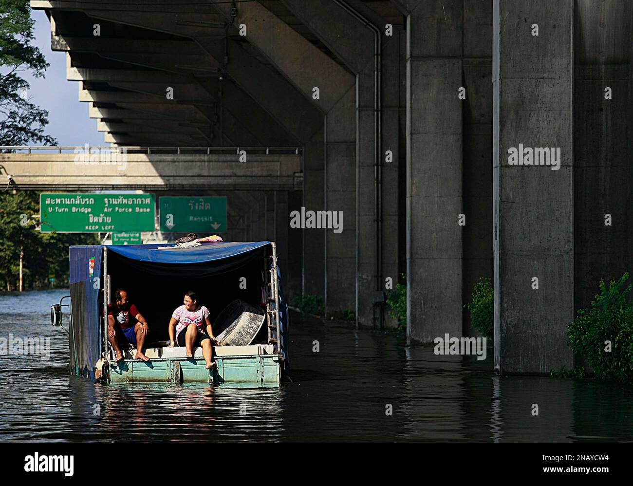 A couple chats on the back of a truck stuck in floodwater on the street outside Don Muaeng airport in Bangkok, Thailand Thursday, Nov. 3, 2011. Thailand's worst floods in more than half a century continued to creep into Bangkok. (AP Photo/Apichart Weerawong) Banque D'Images