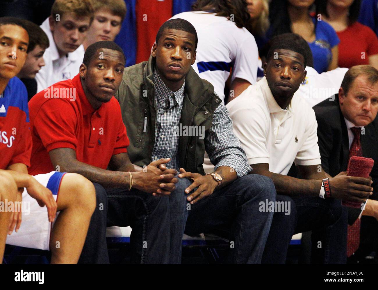 Kansas guard Tyshawn Taylor, left, forward Thomas Robinson, middle, and guard Elijah Johnson, right, sit in street clothes during an exhibition college basketball game against Pittsburg State in Lawrence, Kan., Tuesday, Nov. 1, 2011. Taylor and Johnson were suspended for Tuesday night's game for violating unspecified team rules during the offseason. Robinson missed the game with a hyperextended left knee. (AP Photo/Orlin Wagner) Banque D'Images