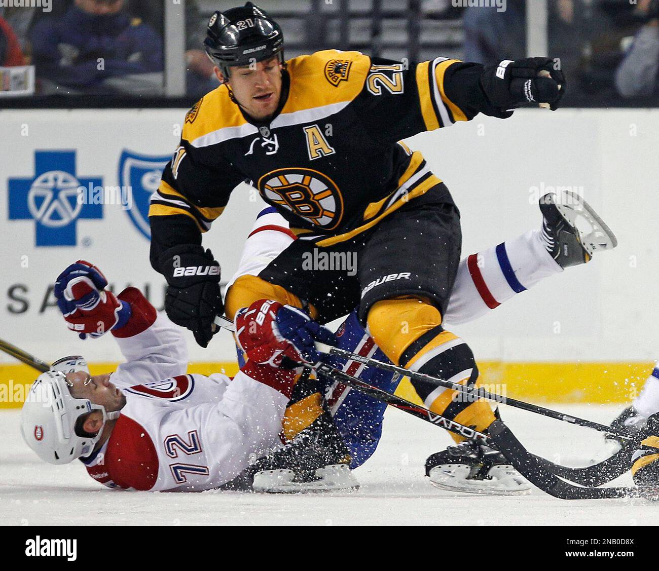 Boston Bruins defenseman Andrew Ference, top, drops Montreal Canadiens left wing Erik Cole to the ice on a hard check in the second period of an NHL hockey game in Boston,Thursday, Oct. 27, 2011. (AP Photo/Charles Krupa) Banque D'Images