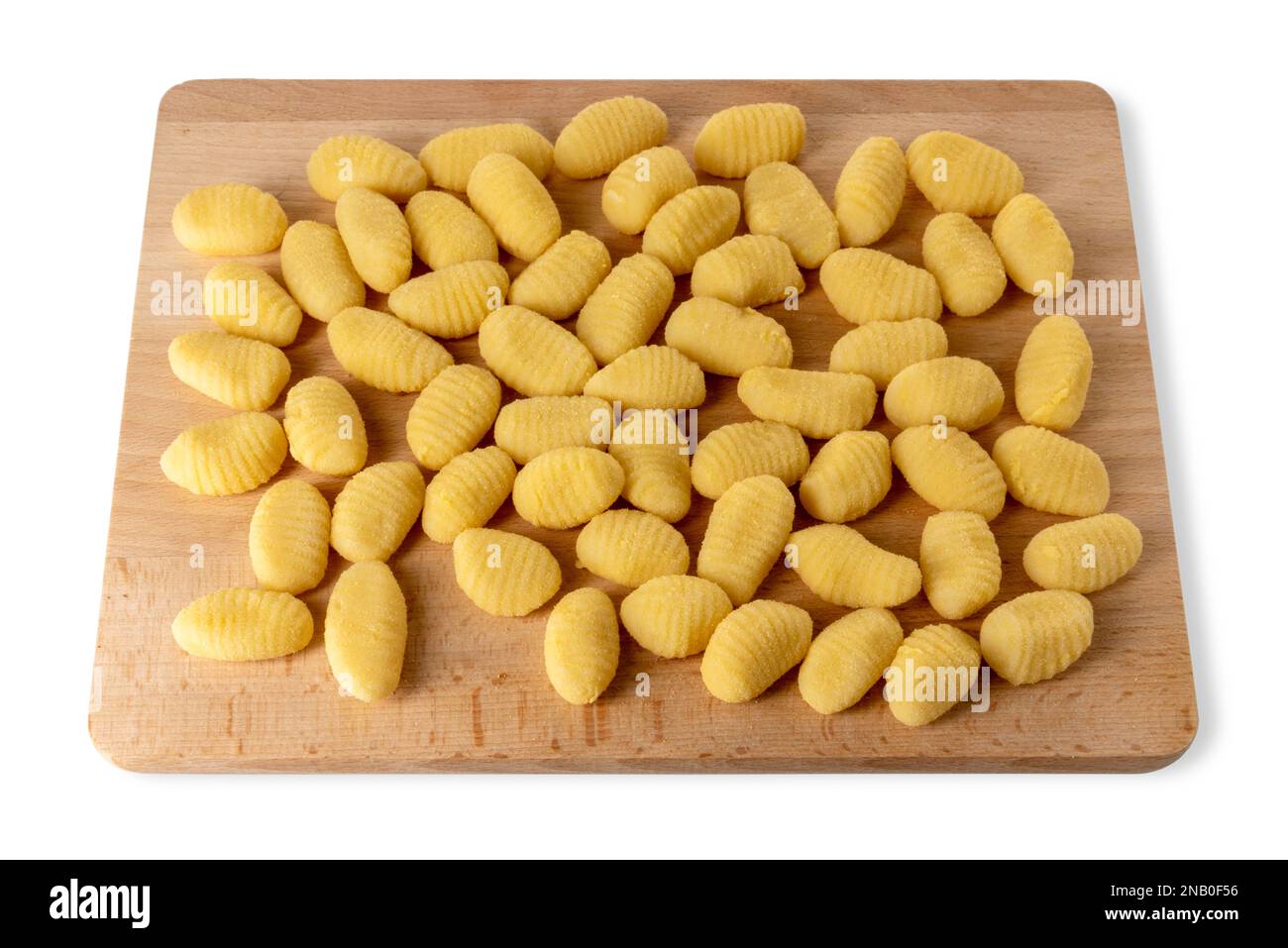 Gnocchi brut sur planche à découper en bois isolée sur blanc avec chemin de coupure. Pâtes à base de boulettes faites de farine et de pommes de terre bouillies Banque D'Images