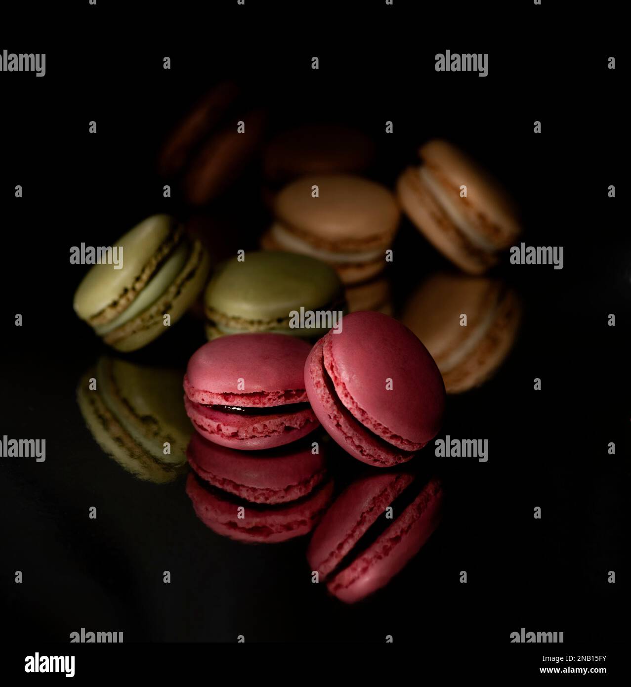 Offrez-vous un moment de décadence avec ces délicieux macarons sur fond noir Banque D'Images