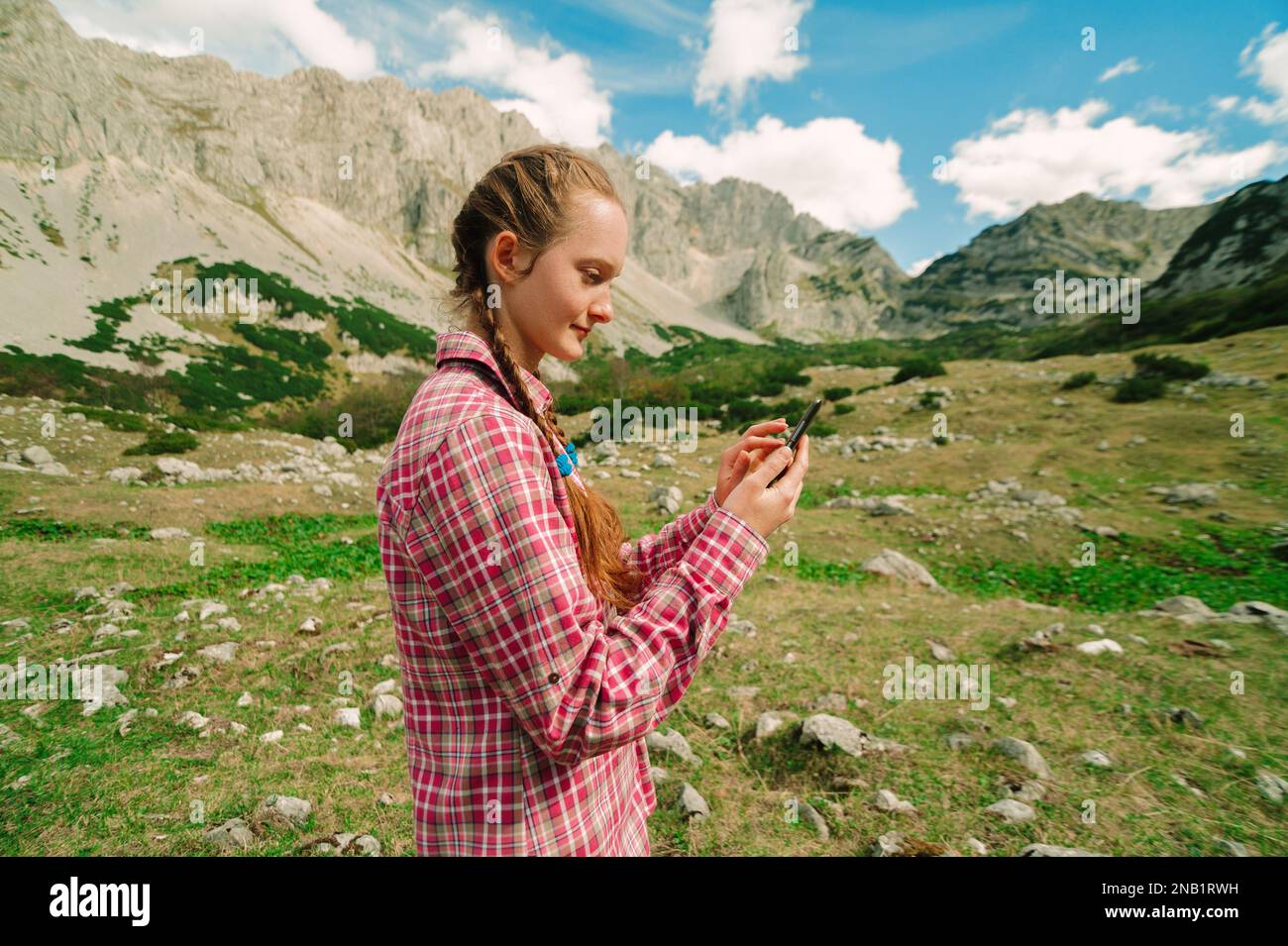 REDHEAD femme voyageur utilisant un smartphone moderne dans les montagnes. Navigation sur téléphone mobile et détente dans la nature avec vue sur le paysage au Monténégro, Durmitor Banque D'Images