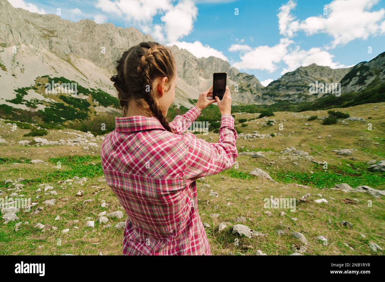 REDHEAD femme voyageur utilisant un smartphone moderne dans les montagnes. Navigation sur téléphone mobile et détente dans la nature avec vue sur le paysage au Monténégro, Durmitor Banque D'Images