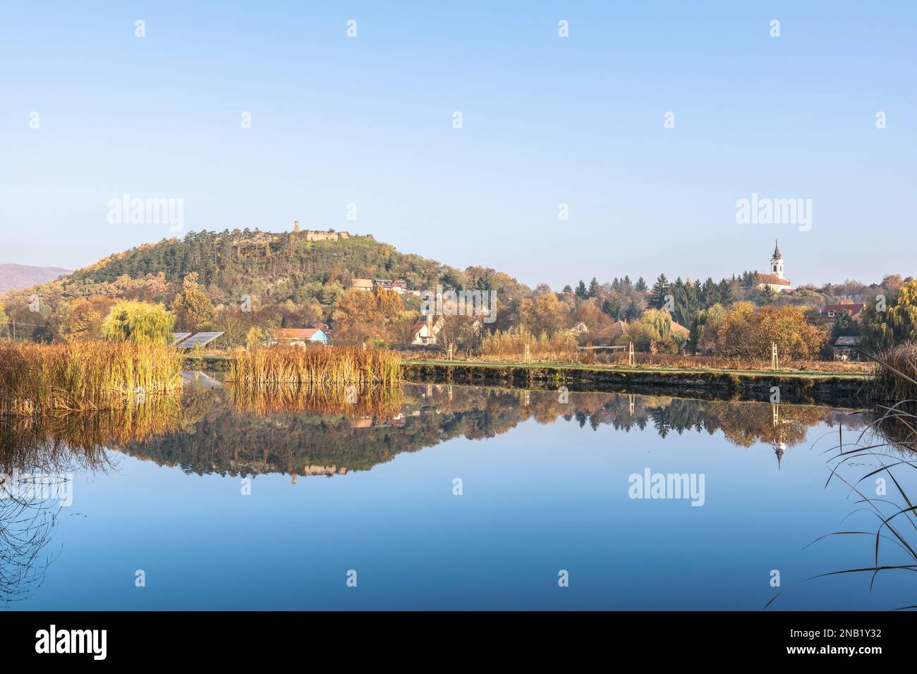 Tourné avec une atmosphère automnale au lac Nógrád, avec le miroir d'eau du château et de l'église de la colonie, Nógrád, Hongrie Banque D'Images
