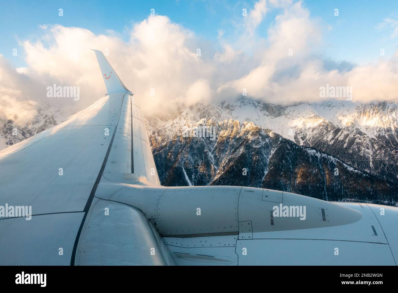 Avion TUI passant des montagnes à l'approche de l'aéroport d'Innsbruck, Autriche Banque D'Images