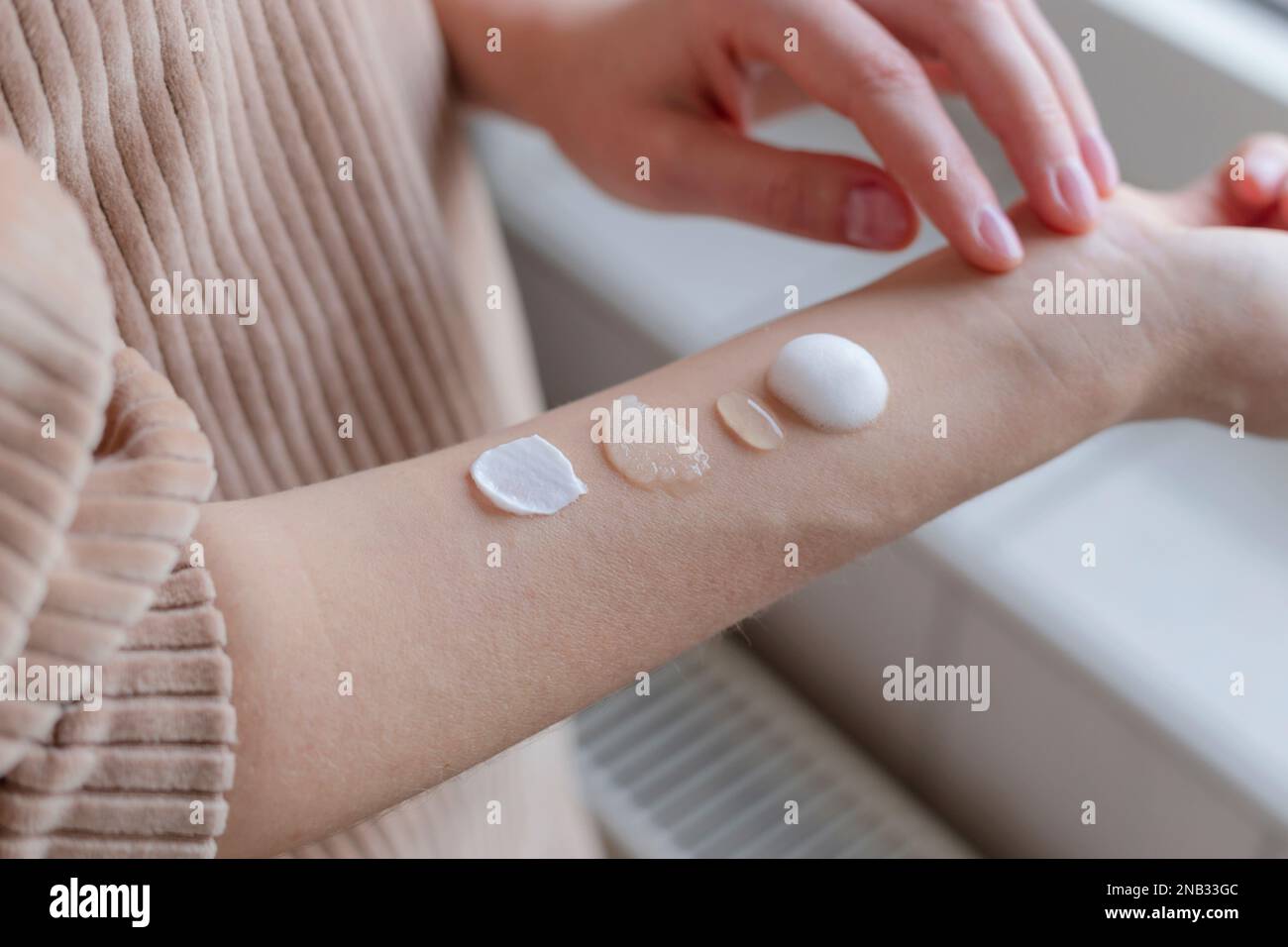 Différents produits de soin de la peau texturés sur la main de la femme. Banque D'Images
