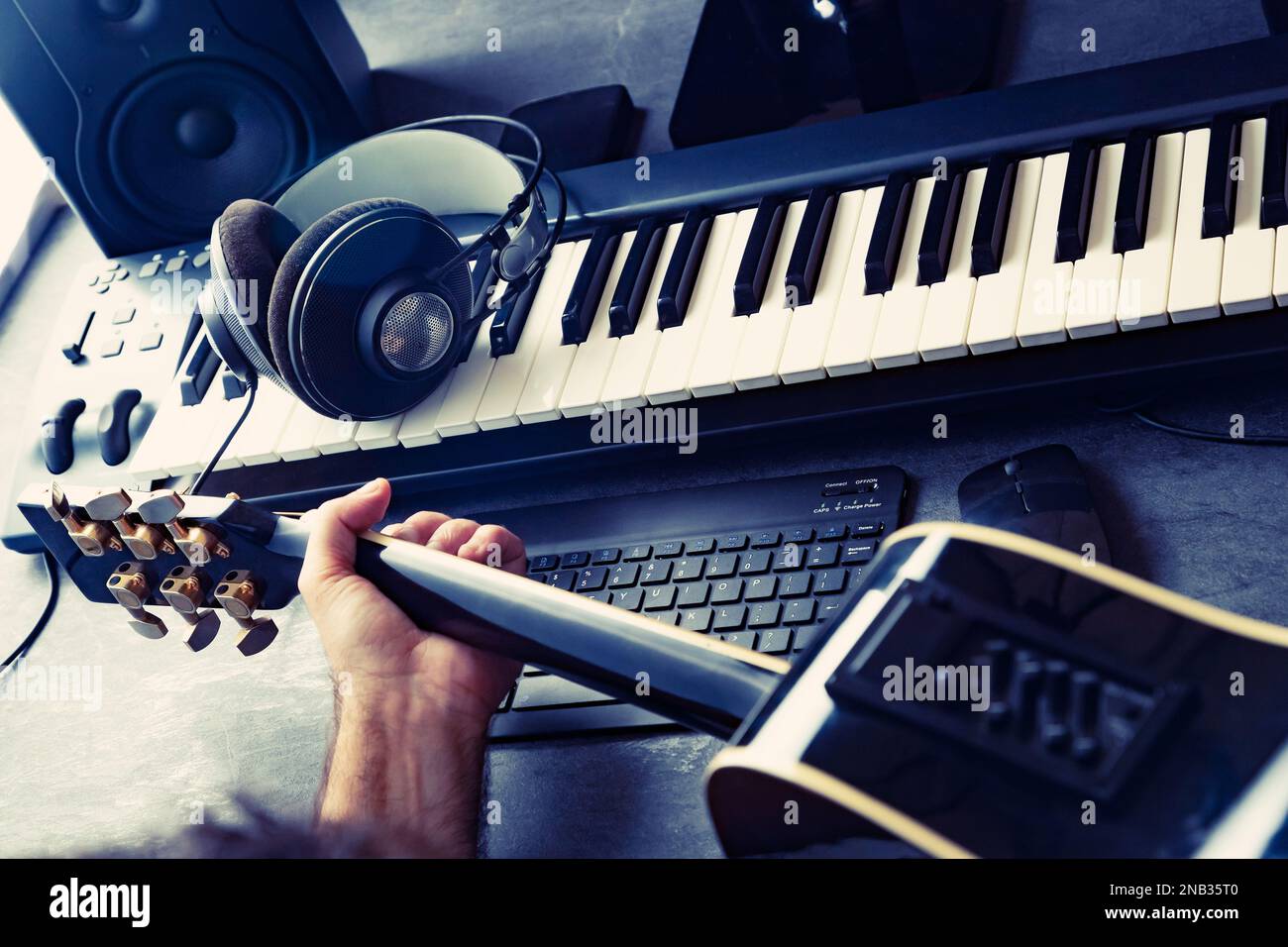Clavier ou synthétiseur et guitariste avec casque et carte son. Concept d'enregistrement et de production de musique sur ordinateur.Studio de musique et studio numérique. Banque D'Images