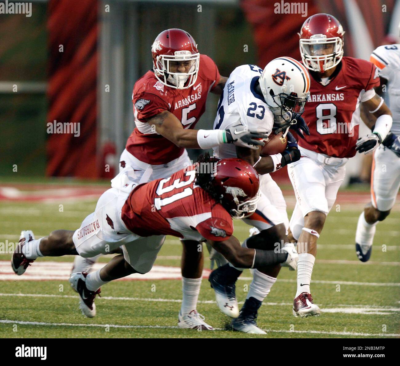 Auburn running back Onterio McCalebb (23) is stopped by Arkansas safety Jerico Nelson (31), safety Tramain Thomas (5), and cornerback Tevin Mitchel (8) during the first half of the NCAA college football game in Fayetteville, Ark., Saturday, Oct. 8, 2011. (AP Photo/Danny Johnston) Banque D'Images