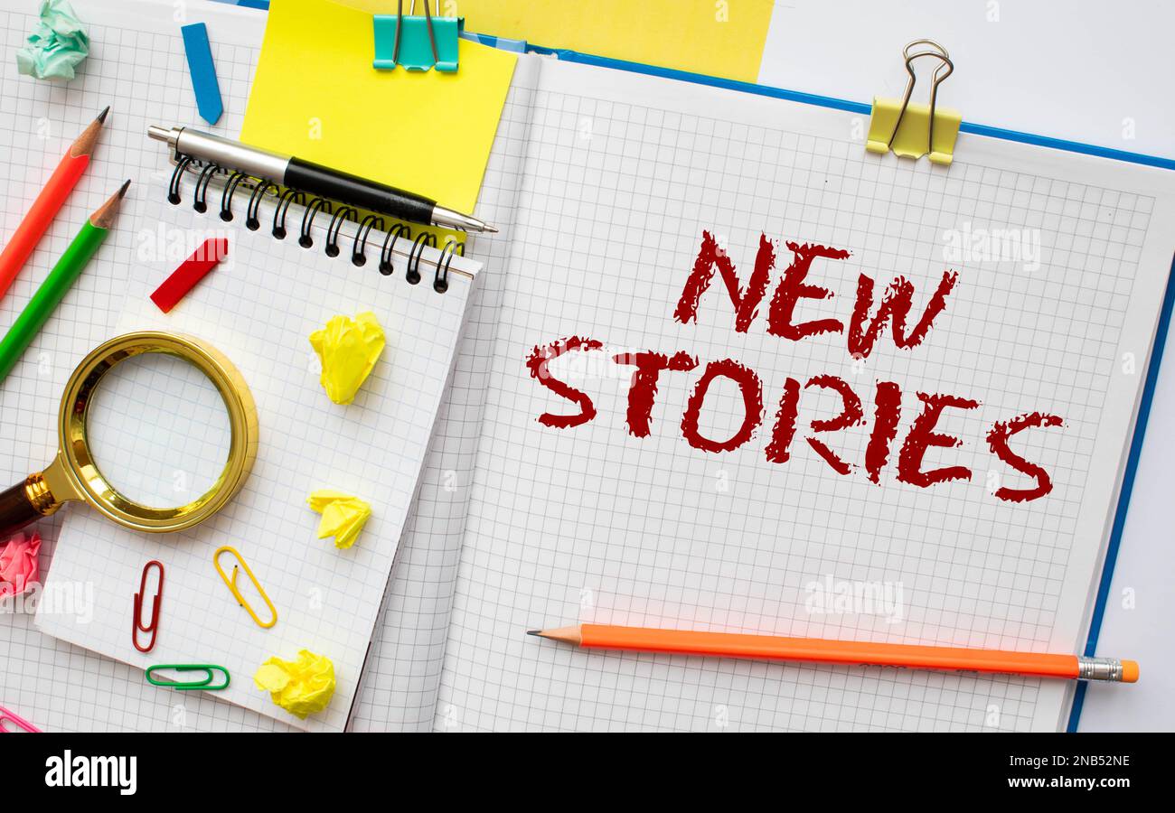 Nouvelles histoires écrites sur des notes adhésives en couleur sur fond blanc. Banque D'Images