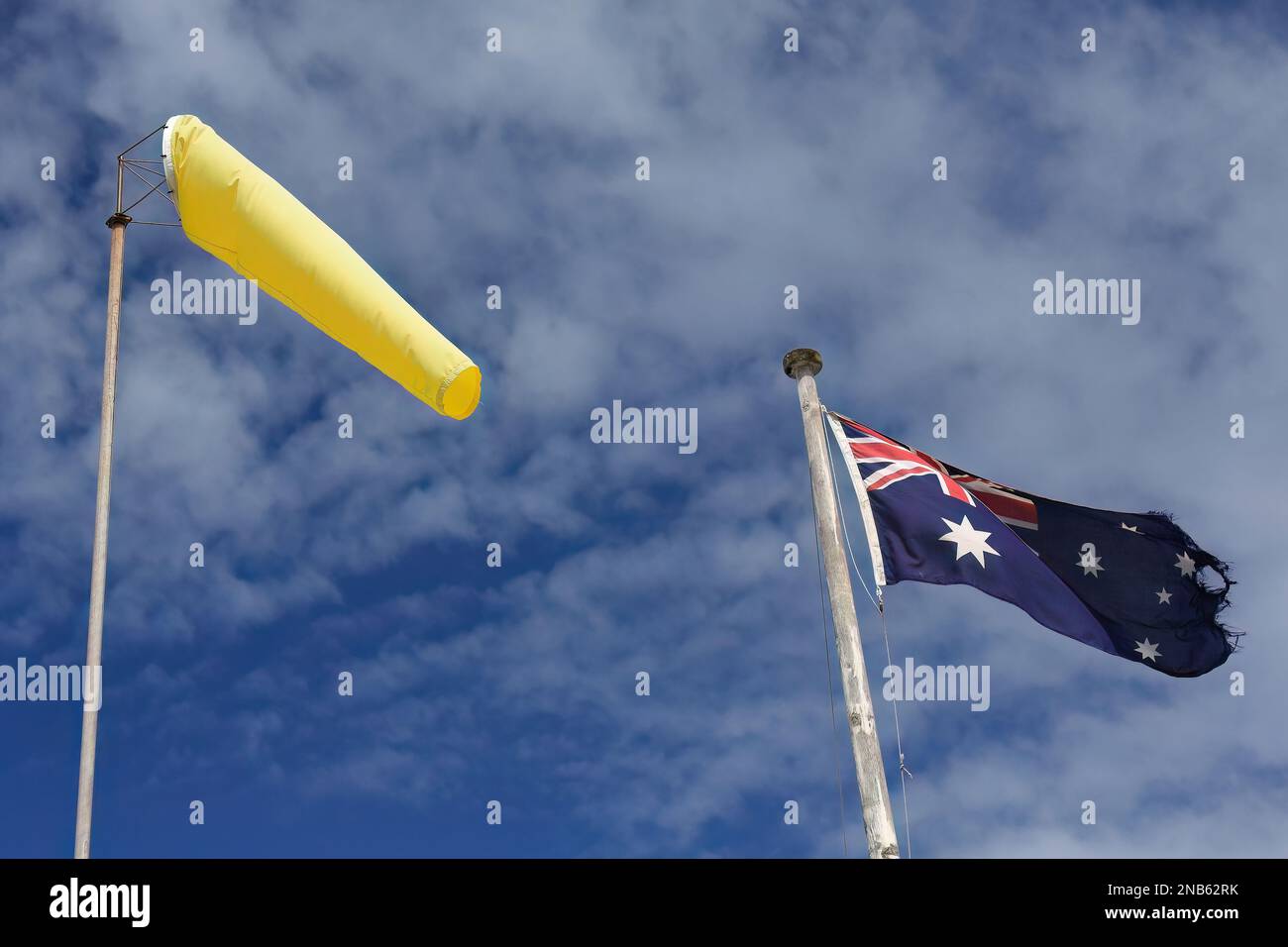 499 Windsock jaune et drapeau national australien qui flotte contre le ciel nuageux. Manly-Sydney-Australie. Banque D'Images