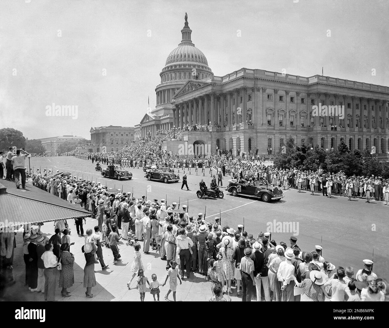 Cars bearing royalty of England and first family of United States are shown swinging in front of Capitol before they journeyed up Pennsylvania Avenue to White House in parade in Washington, D.C., on June 8, 1939. In car on right, leading the parade, are President Franklin Roosevelt and King George VI. Next car bears Queen Elizabeth and Mrs. Eleanor Roosevelt. Marines line the march. (AP Photo) Banque D'Images