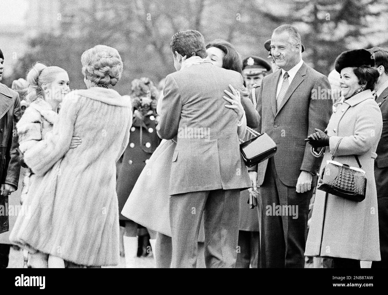 President Richard Nixon and first lady Pat Nixon, starting out on their historic trip to mainland China, say goodbye to their daughters on the South Lawn at the White House in Washington, Feb. 17, 1972. Tricia Cox hugs Mrs. Nixon while the president is kissed by his other daughter, Julie Eisenhower. (AP Photo) Banque D'Images