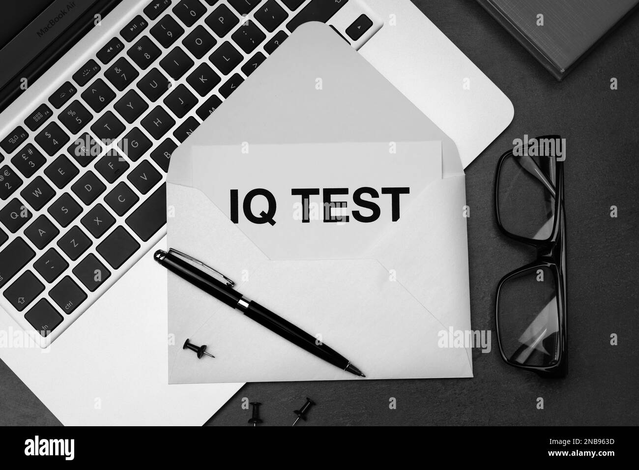 Papier avec mots IQ Test dans une enveloppe, des lunettes et un ordinateur portable sur une table noire, à plat Banque D'Images Papier avec mots IQ Test dans une enveloppe, des lunettes et un ordinateur portable sur une table noire, à plat Banque D'Images