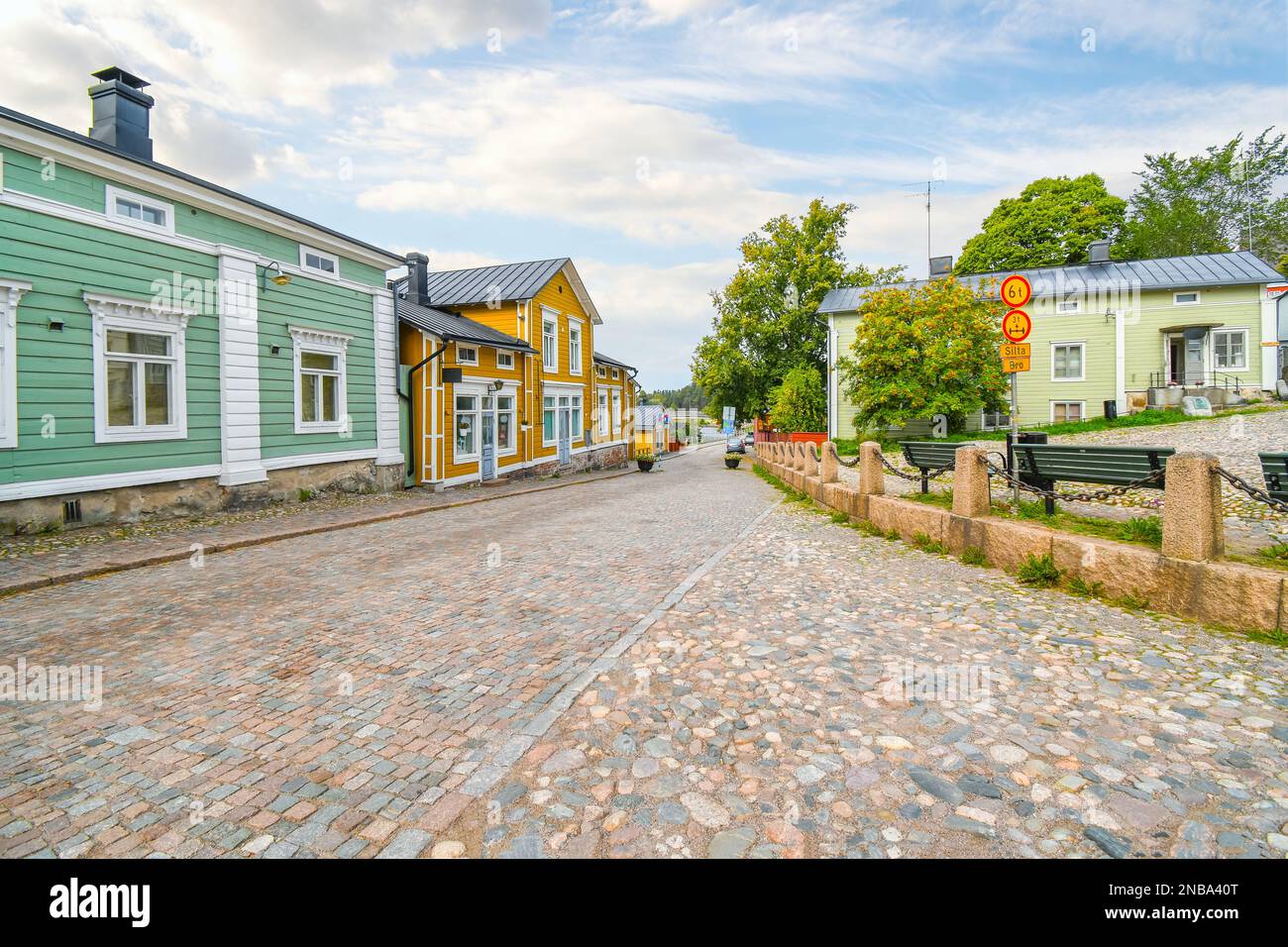 Des bâtiments en bois colorés bordent la route pavée à l'entrée de la vieille ville médiévale de Porvoo. Banque D'Images